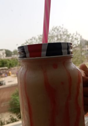 A picture of Banana shake with strawberry drizzle.
