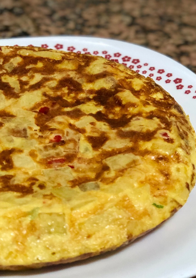 Una foto de Tortilla de patatas con cebolla y pimientos asados
