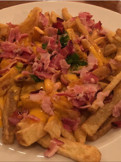 Una foto de Papas con cheddar +panceta y verdeo bien de restobar