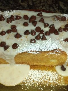 Una foto de Budín de Naranja🍊con glasé y chips de chocolate
