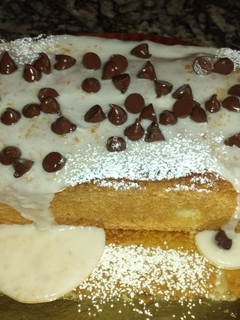 Una foto de Budín de Naranja🍊con glasé y chips de chocolate