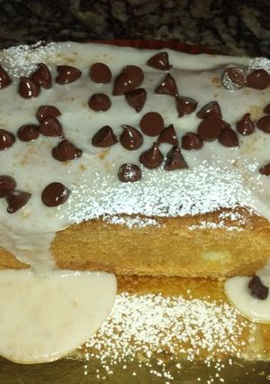 Una foto de Budín de Naranja🍊con glasé y chips de chocolate