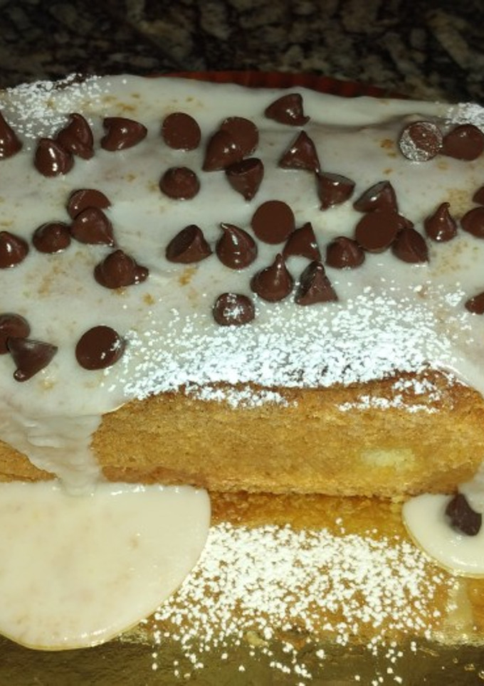 Una foto de Budín de Naranja🍊con glasé y chips de chocolate