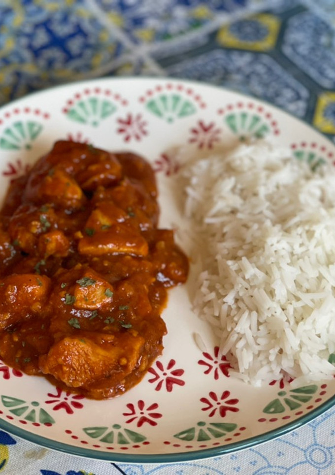 Una foto de Pollo a la mantequilla Indio (butter chicken) con arroz basmati