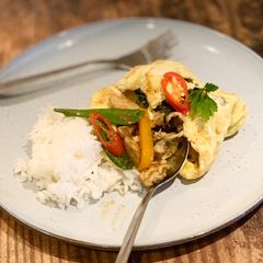 A picture of Chicken green curry stir-fry wrapped in omelette.