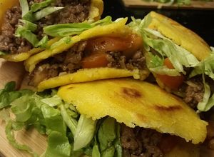 Una foto de Arepas rellenas de Carne condimentada, con tomate queso y lechuga