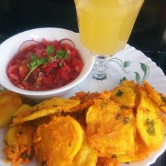 A picture of Bhajiah with tamarind kachumbari and pineapple juice.