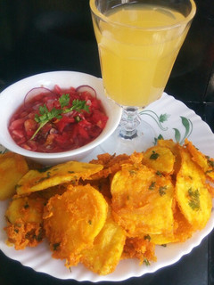 A picture of Bhajiah with tamarind kachumbari and pineapple juice.
