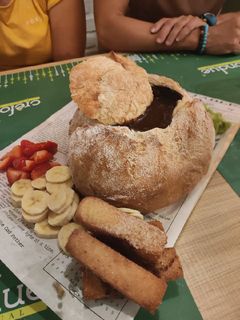 Una foto de Fondue de chocolate en pan payés y frutas