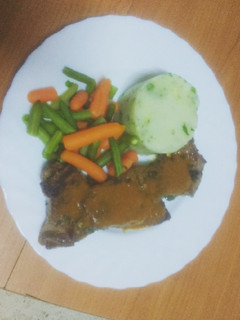 Una foto de Entrecot adobado con puré de papas, verdura y salsa del adobo