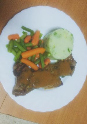 Una foto de Entrecot adobado con puré de papas, verdura y salsa del adobo