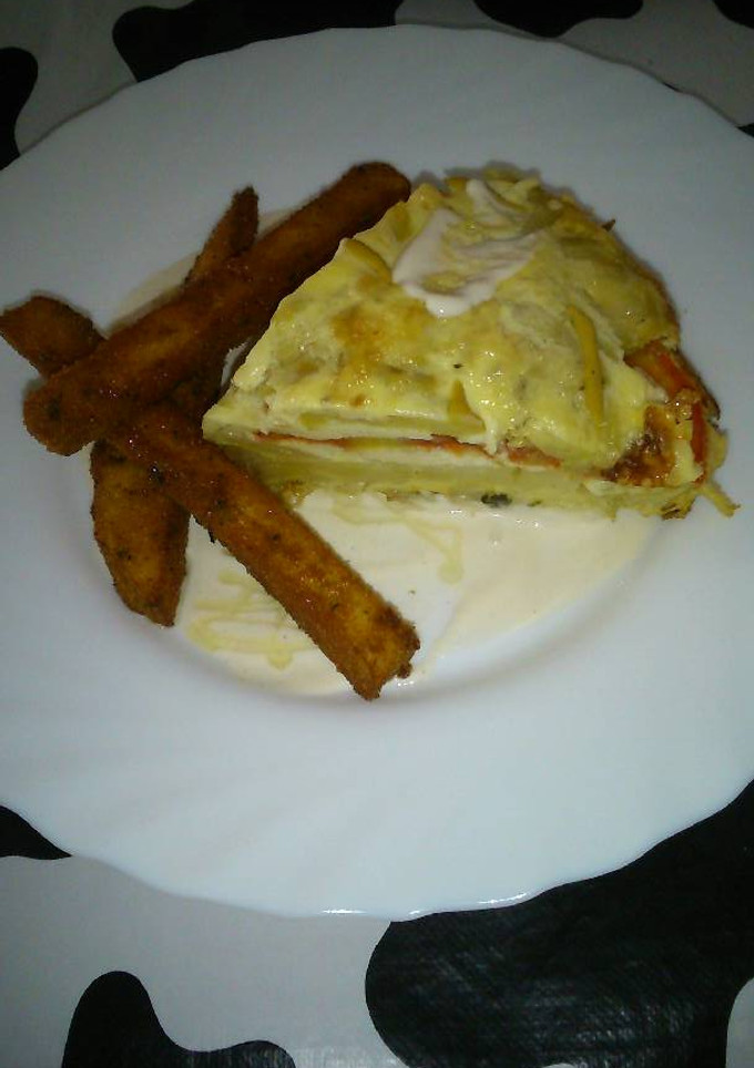 Una foto de Tortilla de patata con calabacín y rodajas de tomate natural