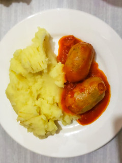 Una foto de Chorizo a la pomarola con puré de papas