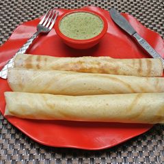A picture of Paper Dosa with coconut chutney.