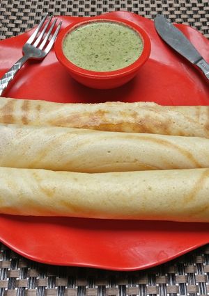 A picture of Paper Dosa with coconut chutney.