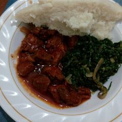 A picture of Meat stew,spinach served with ugali.