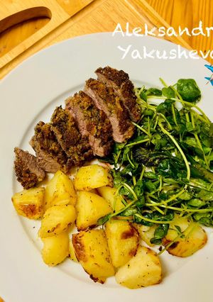 A picture of Pesto, Crusted Lamb Steak and Roast Potatoes with broccoli salad.