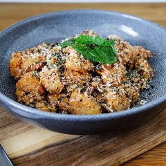 A picture of Gnocchi with vegan cheese & mixed nuts.