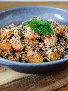 A picture of Gnocchi with vegan cheese & mixed nuts.