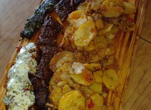 Una foto de Entraña confitada con guarnición de papas, cebolla y morrón