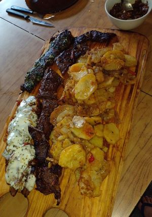 Una foto de Entraña confitada con guarnición de papas, cebolla y morrón