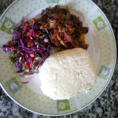 A picture of Stewed beef served with vegetable salad and Ugali.