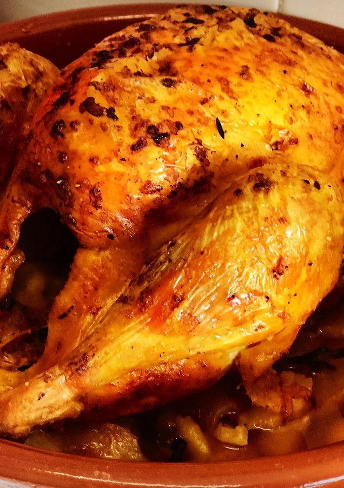 Una foto de Pollo de corral al horno con hierbas aromáticas y achiote