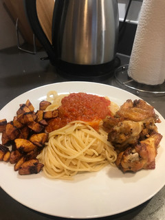 A picture of Spaghetti and fried pepper sauce with wings and plantain.