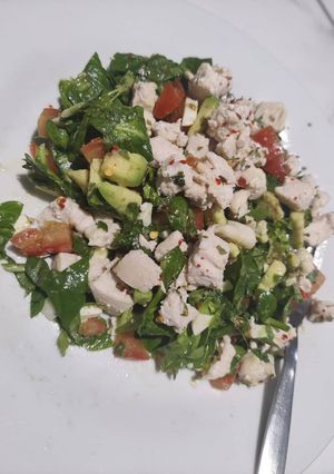 A picture of Spinach Chicken, Avocado, Tomato, Goat Cheese Salad, Drizzled in Olive Oil.