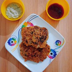 A picture of Potato veggies pancake with coconut chutney & tomato sauce.