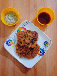 A picture of Potato veggies pancake with coconut chutney & tomato sauce.