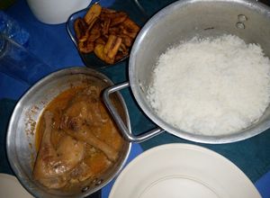 Une photo de Poulet à la sauce d'arachide avec riz blanc et bananes plantain grillées