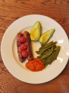 A picture of Kielbasa with asparagus and snap peas.