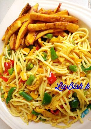 A picture of Spagetti with shredded chicken and fried plantain.