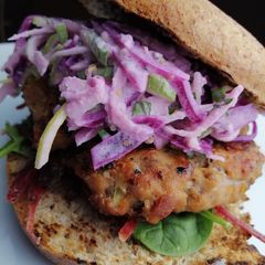 A picture of Pork and chorizo bagel burger + pickled cabbage and apple slaw.