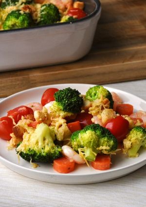 Una foto de Camarones gratinados con brócoli, zanahorias y tomates cherry
