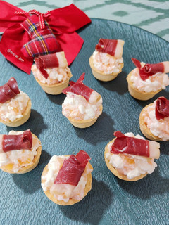 Una foto de Canapé de queso cottage con caqui y jamón de pato