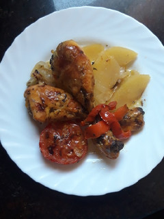 Una foto de Muslos de pollo al horno con tomates y patatas