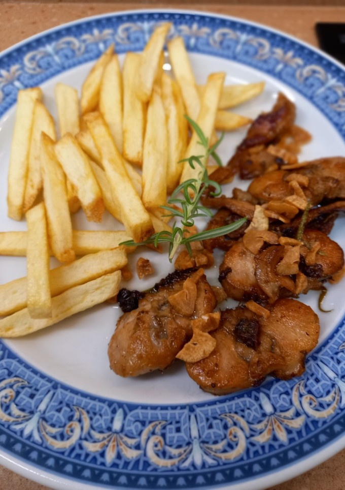 Una foto de Conejo al ajillo, con patatas fritas