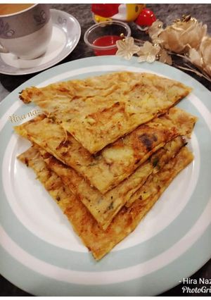 A picture of ALOO kAY PARATHAY WITH KETCHUP AND TEA.