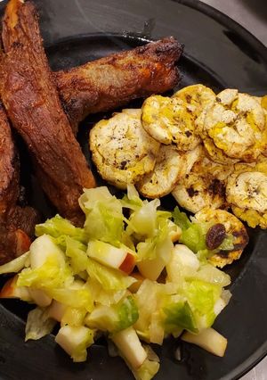 Una foto de Costillas de cerdo con plátano y ensalada.🇩🇴