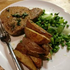 A picture of Tuna steaks, rough cut potato and greens.