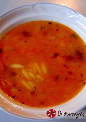 A picture of Orzo soup with vegetables.