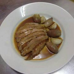 A picture of Duck breast with caramelized shallots and roasted garlic.