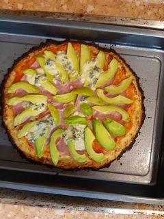 Una foto de Pizza con base de coliflor y aguacate