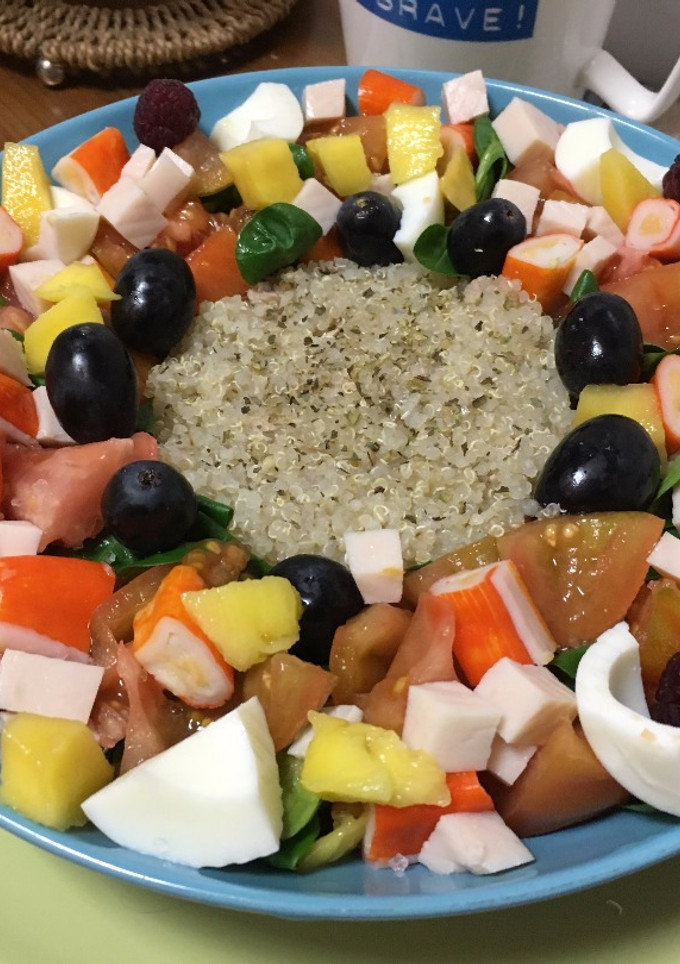 Una foto de Ensalada de quinoa con tomate, pavo, piña, mango, cangrejo, huevo duro y uvas