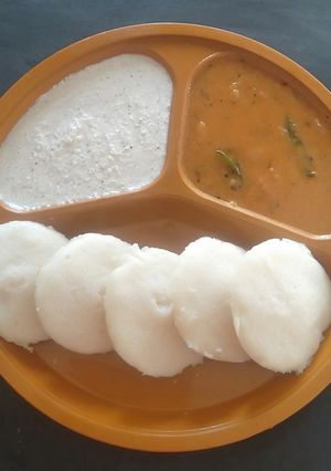 A picture of Idli Sambhar with coconut chutney.