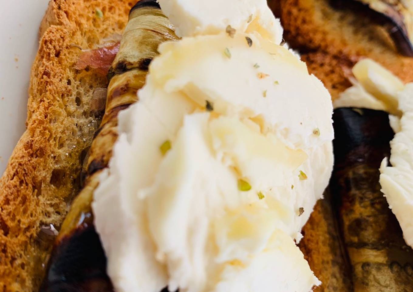 Berenjena con jamón sobre tosta con queso de cabra