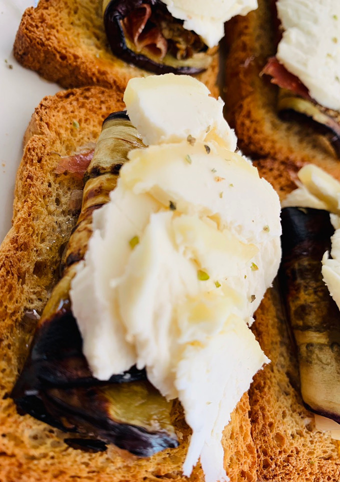 Una foto de Berenjena con jamón sobre tosta con queso de cabra