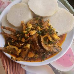 A picture of Boiling yam and fish stew with ugu.